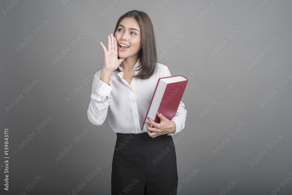 Beautiful teacher Woman holding book on grey background Beautiful teacher Woman holding book on grey background