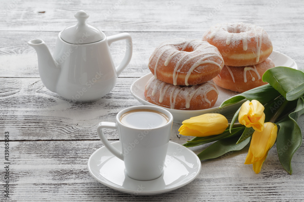 Breakfast with donut and yellow flowers on table Breakfast with donut and yellow flowers on table