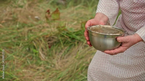 woman is in the hands of the water in the vessel for magical ritual, senior ledi witch comes in the form of a river to collect water in a vessel photo