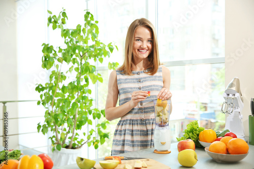 Young woman making fresh ju...