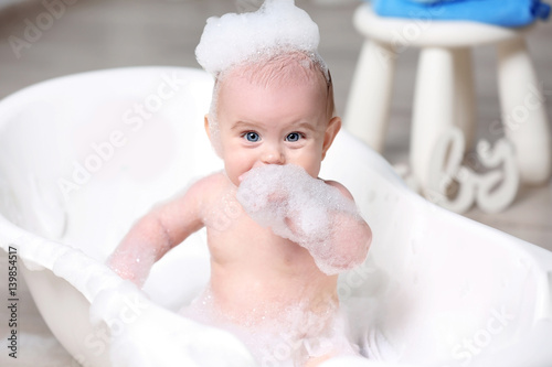 Cute baby washing in bathtu...