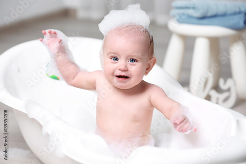 Cute baby washing in bathtu...