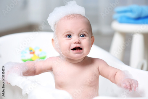 Cute baby washing in bathtu...