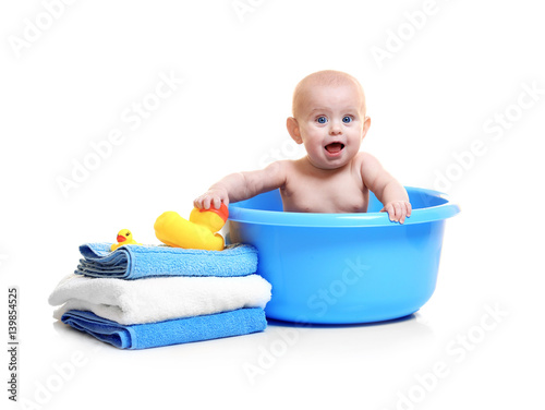 Cute baby in plastic basin,...