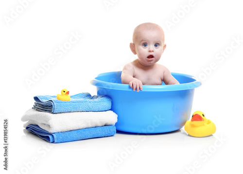 Cute baby in plastic basin,...