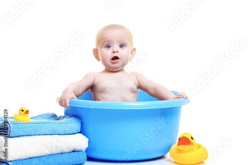 Cute baby in plastic basin,...