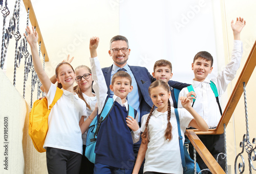 Teacher with children in school corridor during class break