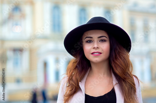 The girl in a coat with black hat on head.
