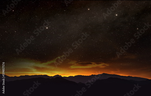 scene of the starry night sky at sunset in the hills