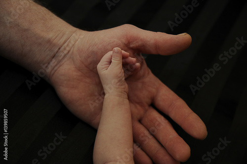 male hand and the handle a newborn