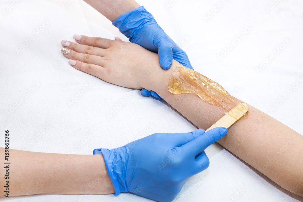 Obraz premium Epilation sugar processes woman passes in a beauty salon 