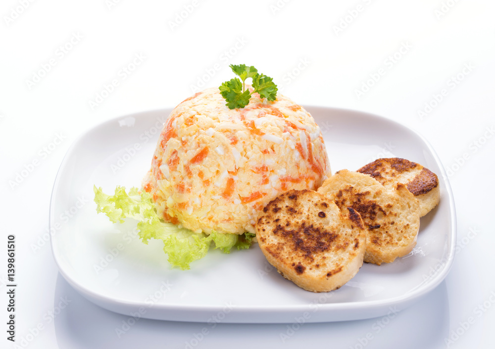 Cheese salad with carrot, eggs, garlic and mayonnaise, decorated with parsley and white bread toasts, white background