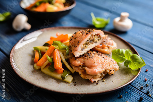 Roasted chicken breasts stuffed with mushrooms, cheese and egg, garnished with steamed vegetable