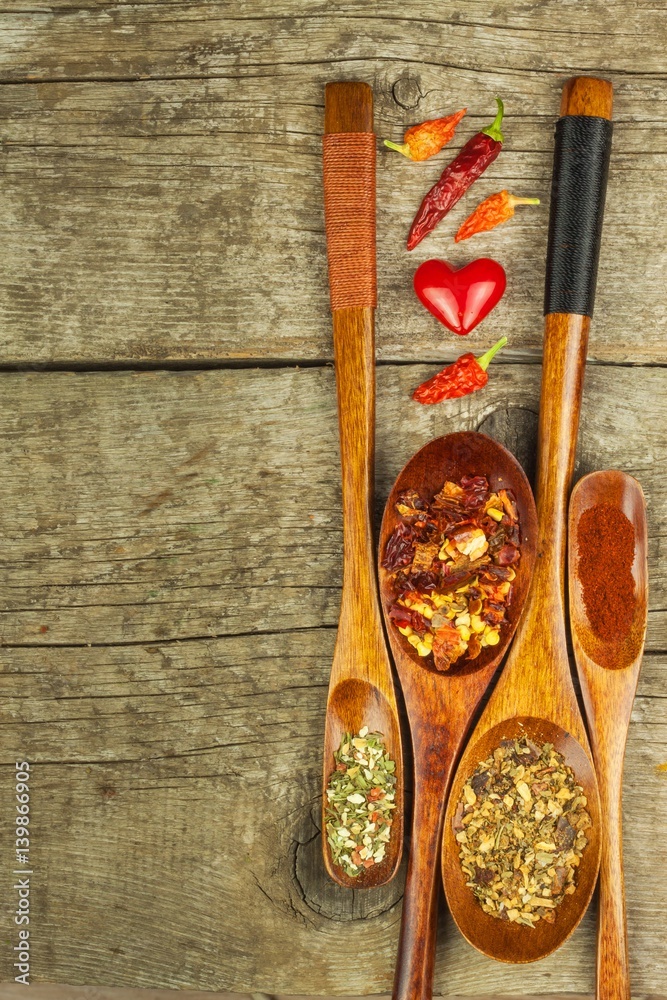 Dried chili peppers on a wooden spoon. Sale of spices. Advertising for sale. Different kinds of hot peppers. Dried chili peppers on a wooden spoon. Sale of spices. Advertising for sale. Different kinds of hot peppers.