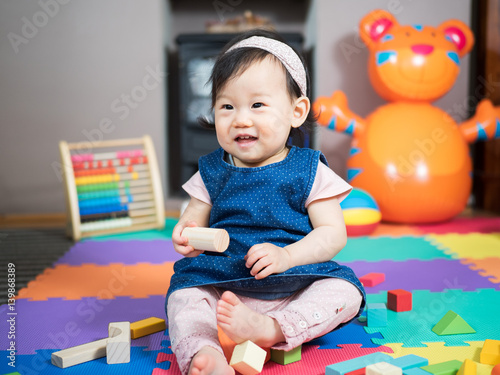 baby girl playing toy blocks at home