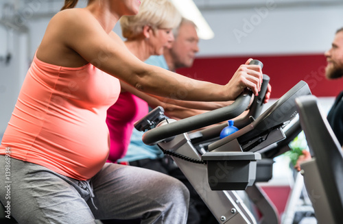 Schwangere Frau beim Spinning im Fitnessstudio