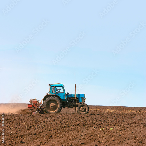 Tractor cultivating field at spring. Russian agriculture