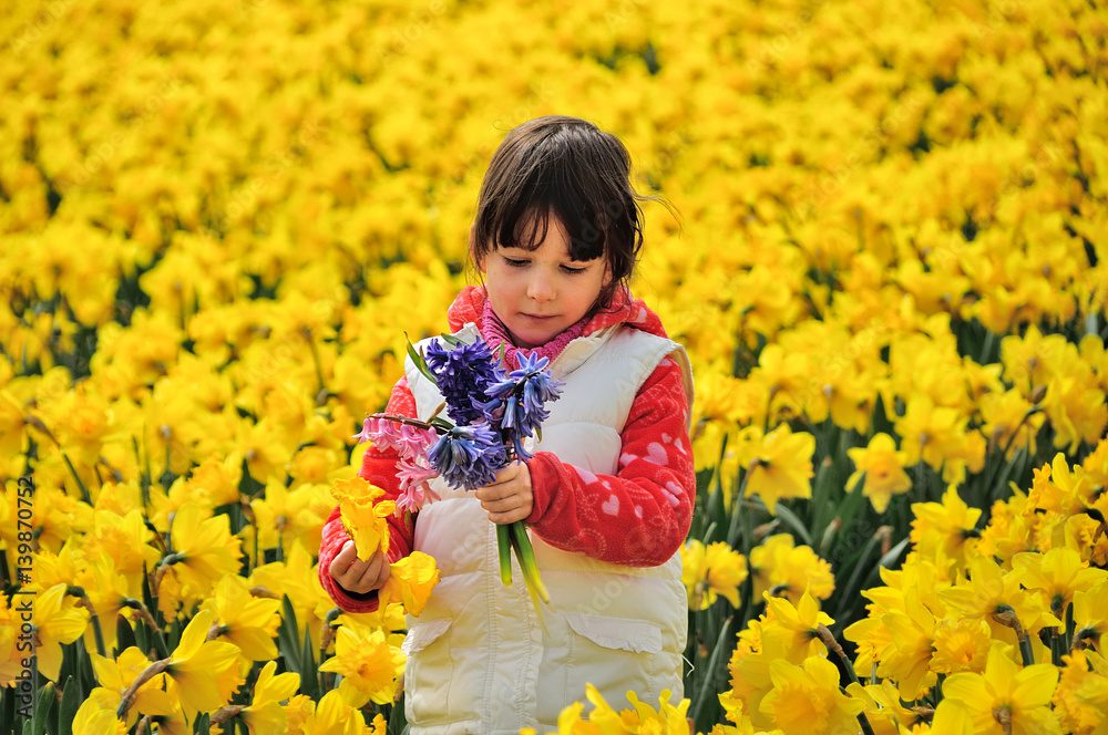 Happy kid with spring flowers on yellow daffodils field, little girl on vacation trip in Netherlands
Happy kid with spring flowers on yellow daffodils field, little girl on vacation trip in Netherlands