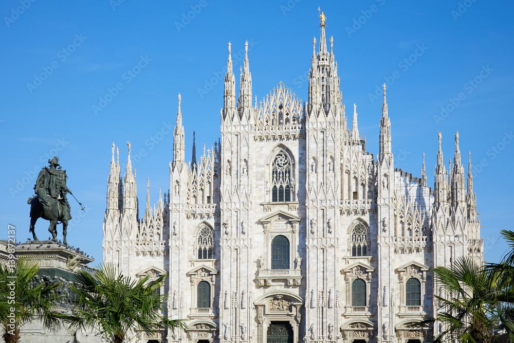 Milan Duomo cathedral with palm trees, blue sky in a sunny day