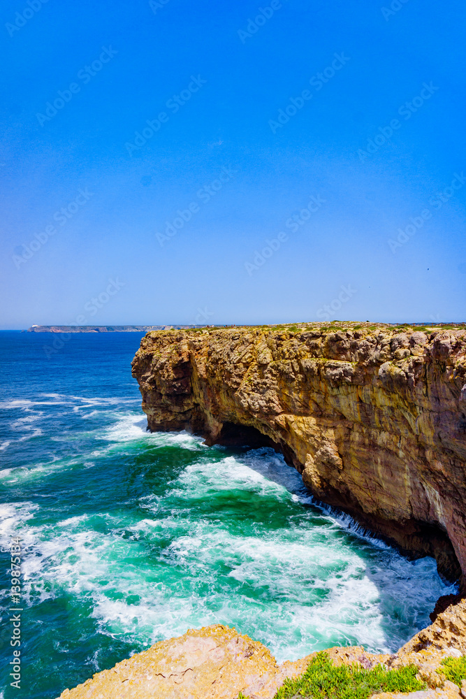 Ocean wave background. Cliff coastline in Sagres, Algarve, Portugal