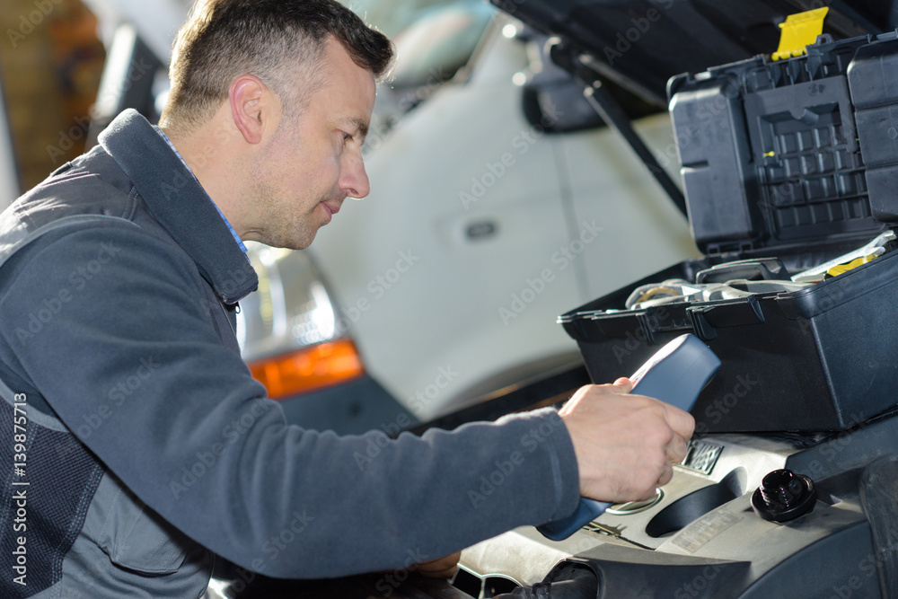 car mechanic replacing oil on engine in garage car mechanic replacing oil on engine in garage