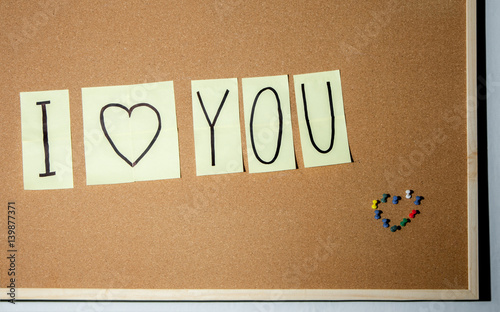 Paper note written with I LOVE YOU inscription on cork board