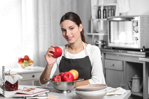 Young woman holding apple a...