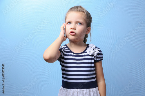 Cute little girl talking by...