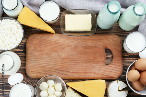 Cutting board with space for text in frame of dairy products © Africa Studio