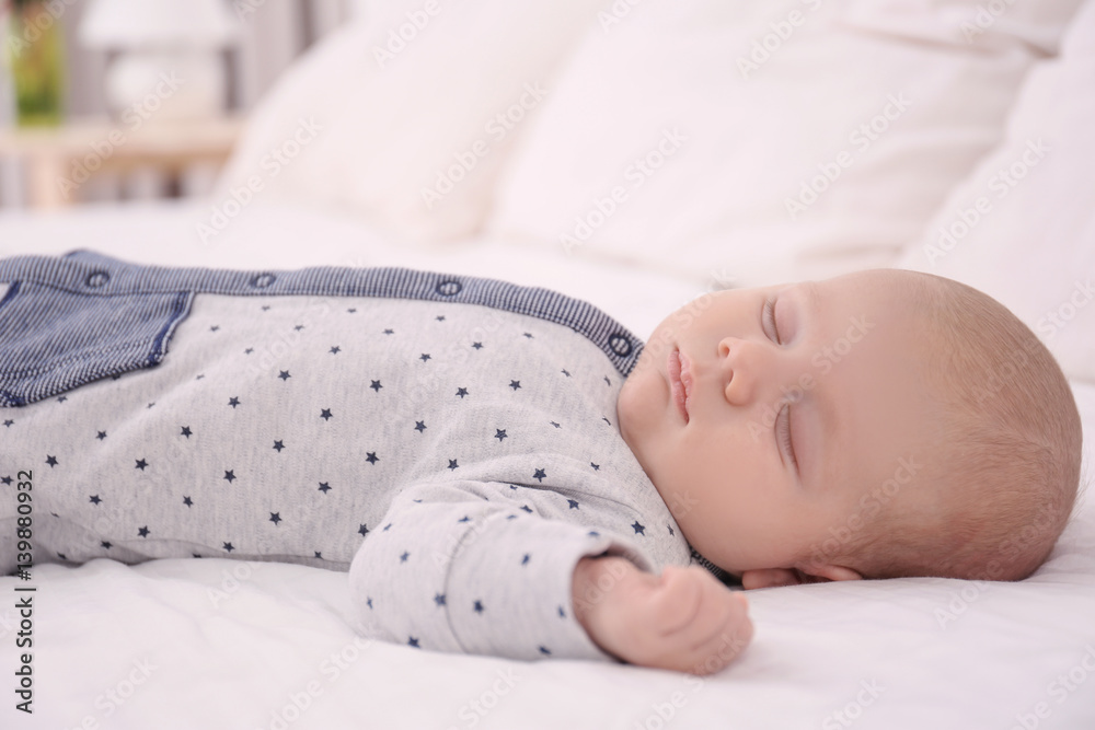 Cute little baby sleeping on bed at home
