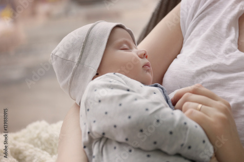 Young woman with cute sleeping baby at home  closeup