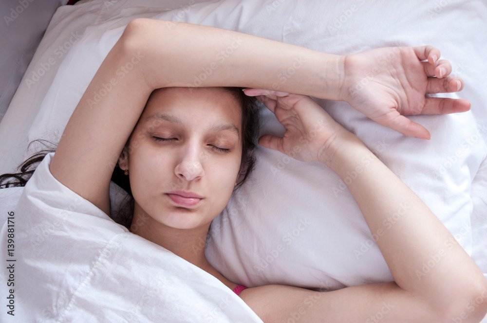 Girl brunette sleeping in her bed on white pillow Girl brunette sleeping in her bed on white pillow