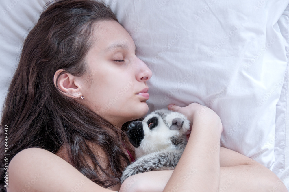Teenager girl sleeping with a soft toy Teenager girl sleeping with a soft toy