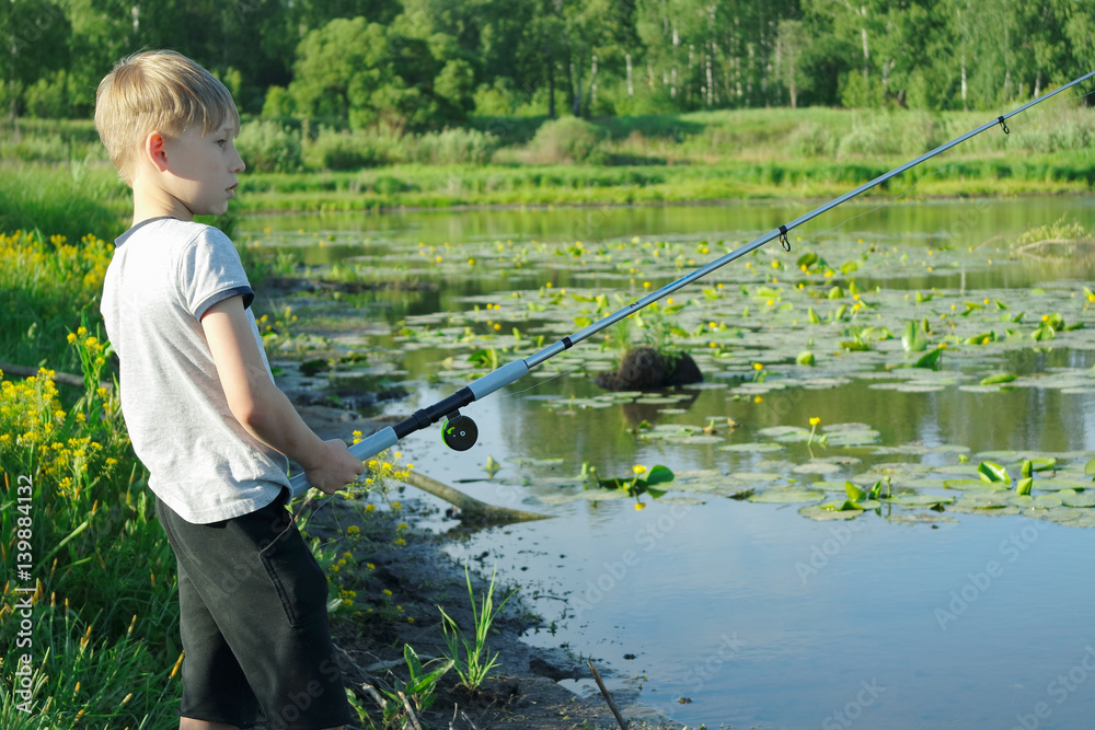 Young boy fishing at river coast. Young boy fishing at river coast.