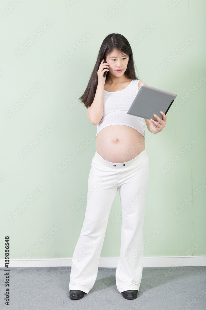Fototapeta premium young pretty pregnant woman with tablet