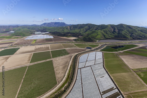 Aerial view of agricultural land and Santa Monica Mountains peaks in Ventura County, California.