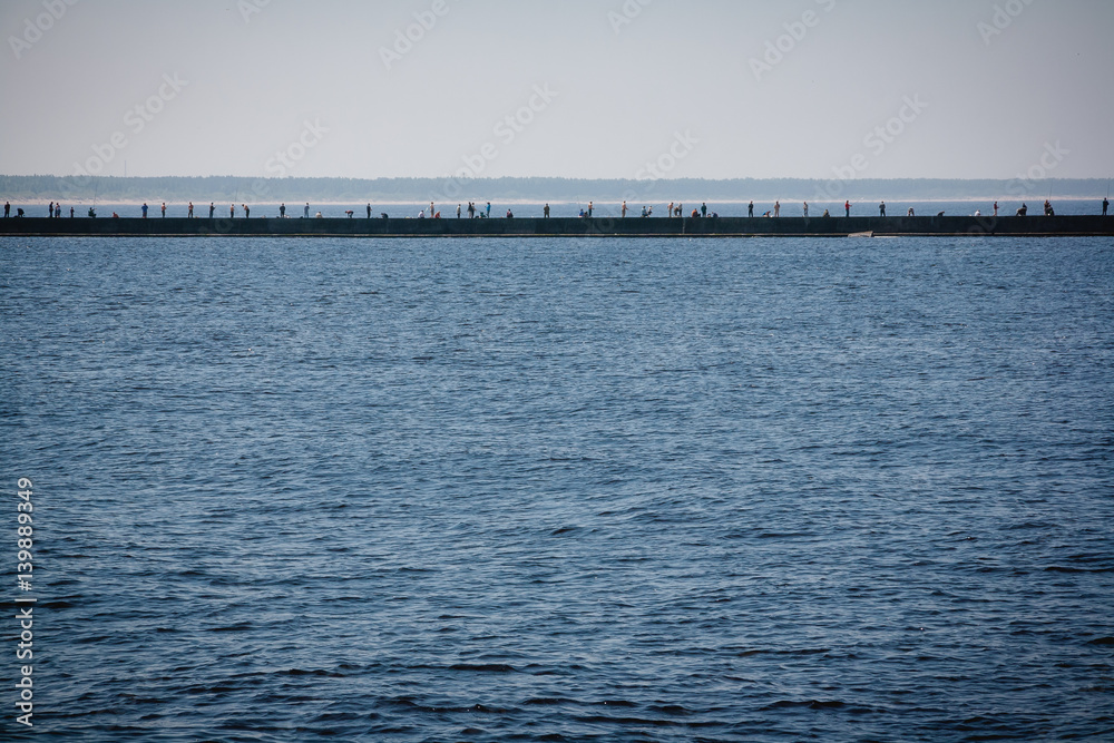 Anglers standing on the pier and catching fish Anglers standing on the pier and catching fish