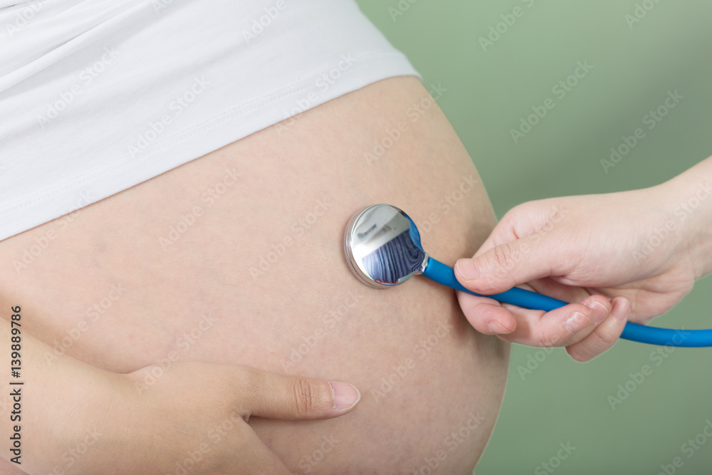 Fototapeta premium pregnant woman's belly and stethoscope
