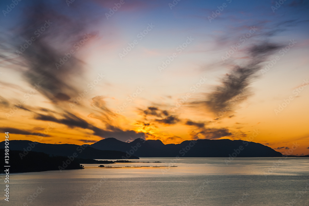 Beautiful view of the fjord on a background of a bright sunset sky. Norway