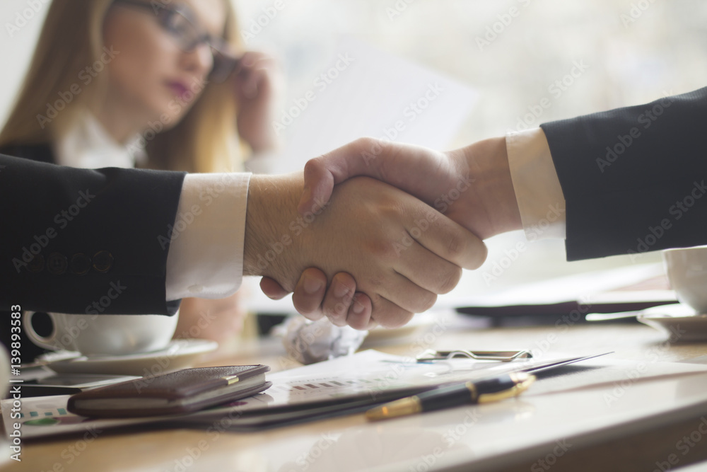handshake business partners before signing the contract on the background of the workplace handshake business partners before signing the contract on the background of the workplace
