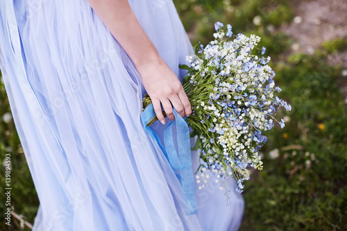 Girl with a lilac bouquet of lilac in the garden.  Lilies of the valley and forget-me-nots