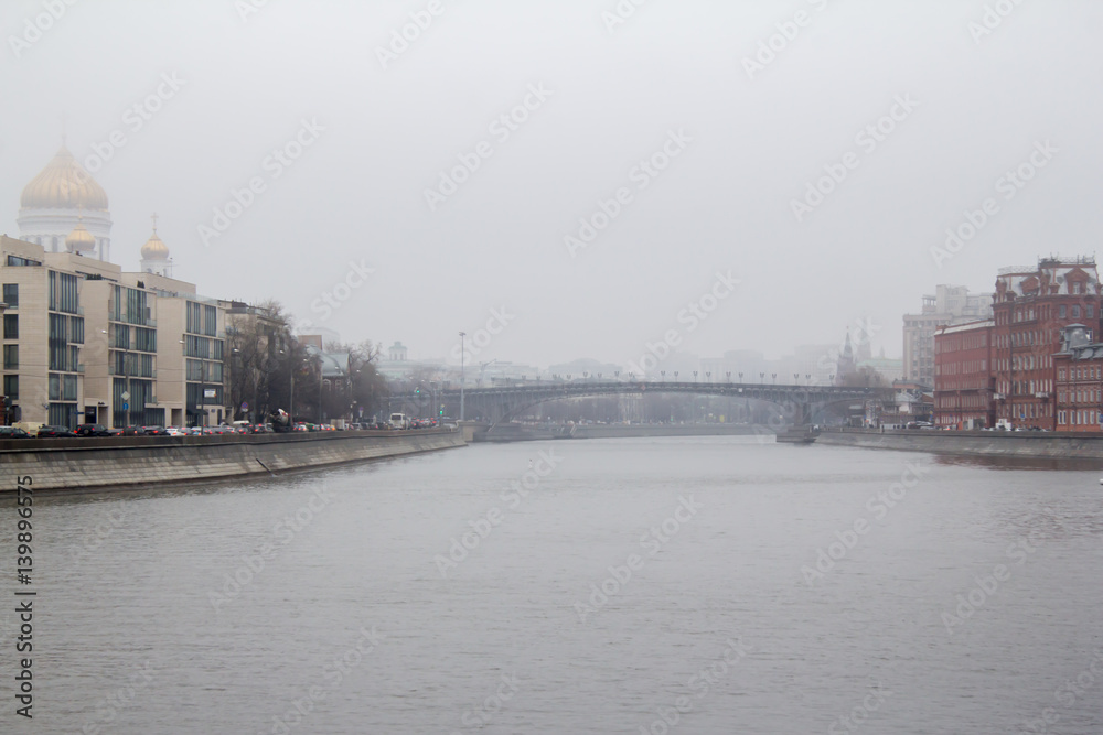 Foggy spring morning on the embankment of the river