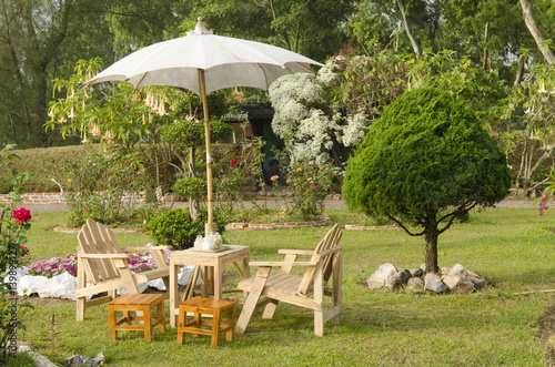 beautiful garden with flower and wooden table and chairs - home decoration