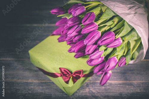 Fototapeta Naklejka Na Ścianę i Meble -  Big bouquet of spring purple tulips on a wooden table.