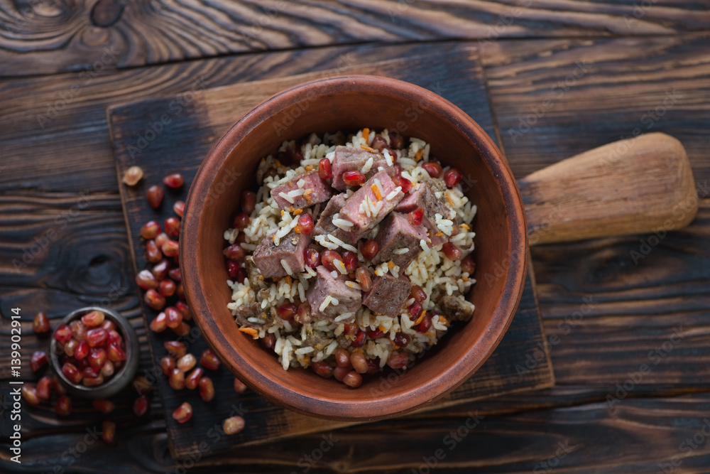Ceramic bowl with pilaf on a rustic wooden background, view from above Ceramic bowl with pilaf on a rustic wooden background, view from above