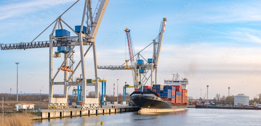 Szczecin ,Poland-January 2017:sea container flows into port for unloading harbor cranes and gantries