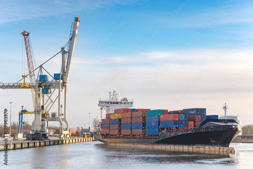 Szczecin ,Poland-January 2017:sea container flows into port for unloading harbor cranes and gantries