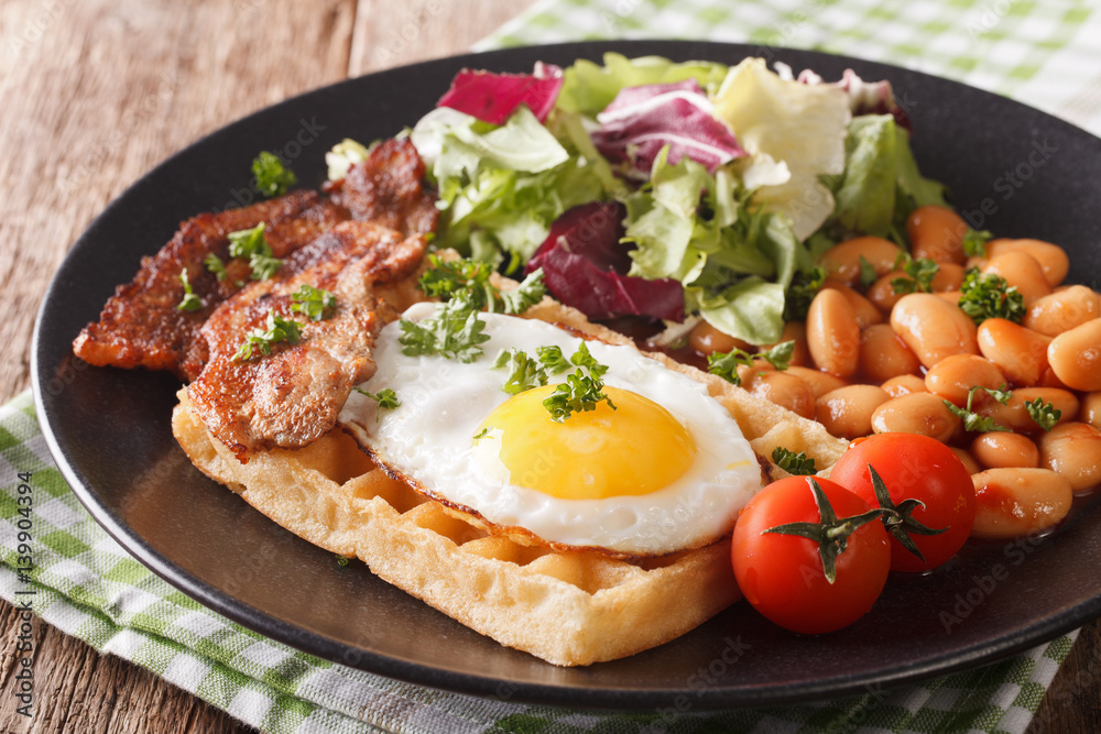 English breakfast with fried egg, waffles, bacon, salad and beans close-up. horizontal English breakfast with fried egg, waffles, bacon, salad and beans close-up. horizontal