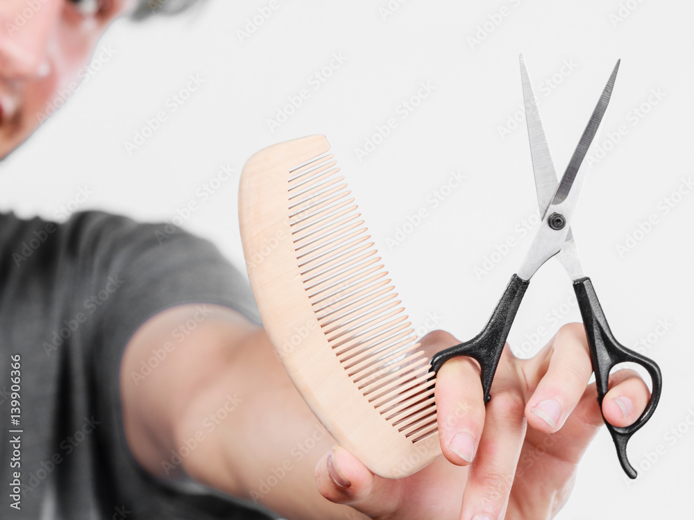 Obraz premium Male hand with scissors and comb