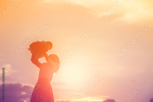 Happy Mother with baby sunset.